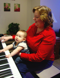Connie teaching her grandson to play piano
